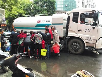 在儒学路和龙门路交叉口，安陆城管部门的车辆向附近居民发放生活用水